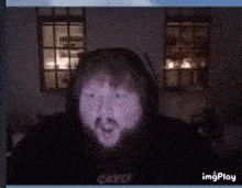 a man with a beard is wearing a black hoodie that says catch on the front