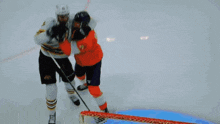 two ice hockey players are fighting on the ice and one has the number 28 on his jersey
