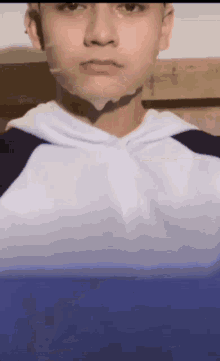 a close up of a young man 's face with a hoodie on
