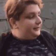 a close up of a woman 's face smiling while sitting down .