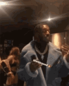 a man in a blue coat is singing into a microphone with the word unreleased written on it