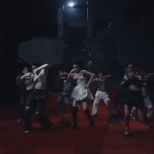 a woman in a white dress is dancing on a red carpet in front of a group of people .