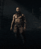 a man with a beard and a tattoo on his arm is standing in the dark