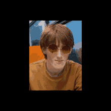 a young man wearing red sunglasses and a yellow shirt