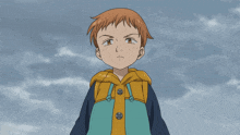 a young boy in a yellow and blue jacket stands in front of a cloudy blue sky