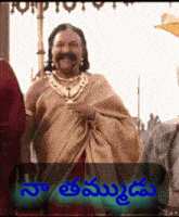 a man with a mustache and a necklace stands in front of a sign that says ' na '