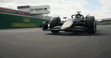 a race car is going down a track with a fence in the background