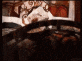 a woman is laying on a bed with a swirl on the headboard