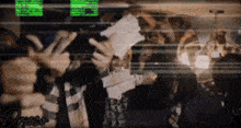 a group of people are standing in a room with their hands up .