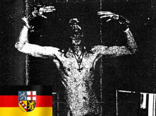 a black and white photo of a naked man with a german flag in the background