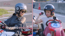 a woman wearing a helmet is talking to another woman wearing a helmet on a go kart