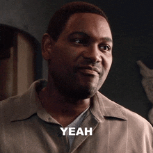 a man wearing a grey shirt says yeah