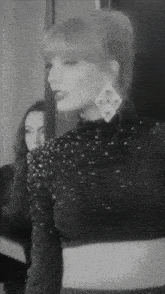 a black and white photo of a woman wearing a black dress