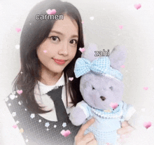a girl holding a stuffed animal with the name carmen and zahi written on it