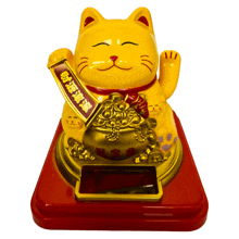 a yellow statue of a cat holding a banner with chinese writing on it