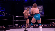 two men are wrestling in a ring and one of them is being lifted in the air .