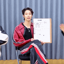 a man in a red jacket is holding a clipboard that says xlov on it