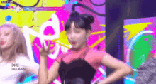 a woman is dancing on a stage in front of a colorful background