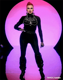 a drag queen is standing in front of a purple circle that says tumblr on it