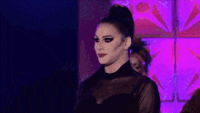 a group of people are standing on a stage with a purple background