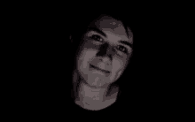 a close up of a man 's face in a dark room .