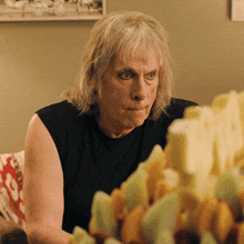 a man with gray hair is sitting in front of a table full of food