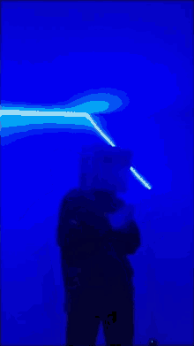 a person is standing in front of a blue light beam
