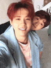 two young men are taking a selfie together in a room .