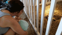 a woman looks at a turtle in a cage