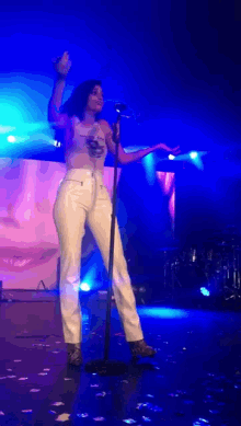 a woman singing into a microphone on stage