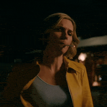 a woman in a yellow jacket looks up at the sky