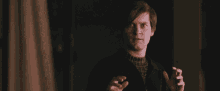 a man in a black jacket is making a funny face with his hands outstretched