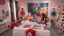 two little girls are sitting on a bed in a room with a painting on the wall