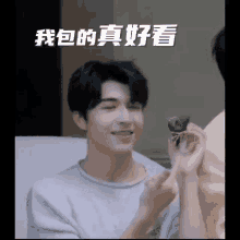 a man with chinese writing on his face is holding something in his hand