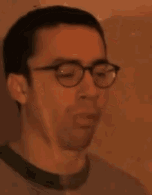 a close up of a man wearing glasses and a green t-shirt
