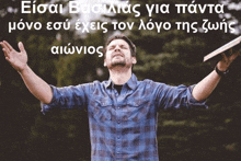 a man in a plaid shirt is holding a bible with his arms in the air
