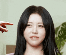 a close up of a woman 's face with a person 's hand pointing to it