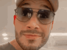 a man with a beard wearing sunglasses and a baseball cap
