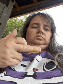 a woman in a purple shirt with snoopy on it
