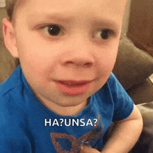 a young boy is making a funny face while sitting on a couch and making a funny face .