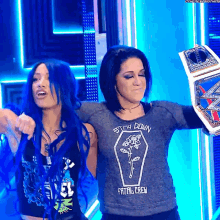 a woman with blue hair is wearing a shirt that says stay down fatal crew