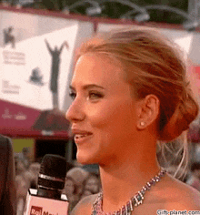 a woman talking into a microphone that says rai