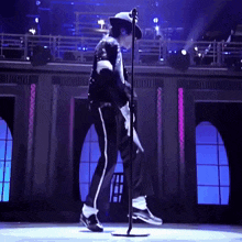 a man is standing in front of a microphone and dancing