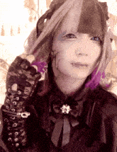 a girl with purple hair is wearing a black shirt with a bow