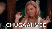 a woman in a white tank top is dancing with her hands in the air and the words chugaahvee are written on the screen .