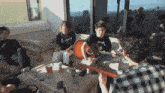 a man in a metallica shirt is playing guitar
