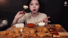 a woman is sitting at a table eating a variety of fried food