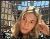 a woman with blonde hair is sitting in a chair and looking at the camera