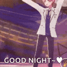 a man in a suit and tie is standing in front of a crowd with his arms in the air and says `` good night '' .