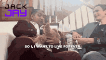 two men are sitting on a couch with a dog and the words " so i want to live forever " above them